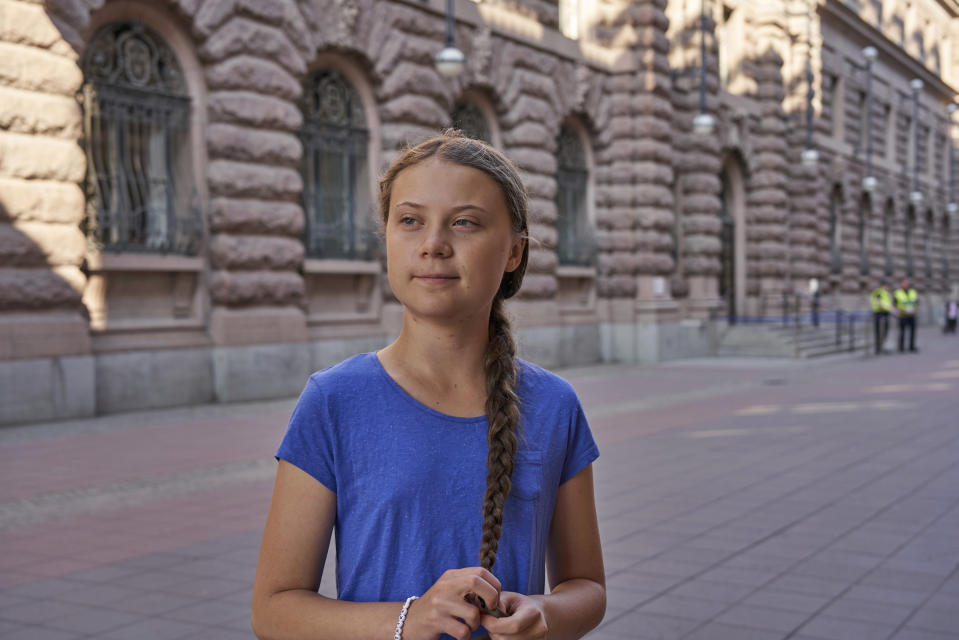 In this photo taken on Friday, July 26, 2019, Greta Thunberg stands next to Swedish parliament in Stockholm. Thunberg, the Swedish teenager whose social media-savvy brand of eco-activism has inspired tens of thousands of students in Europe to skip classes and protest for faster action against climate change, said Monday, July 29, 2019 that she plans to take her message to America the old-fashioned way: by boat. (AP Photo/David Keyton)