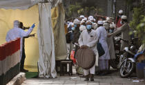 FILE- In this Tuesday, March 31, 2020, file photo, Indian paramedics after screening take down the names of Muslims wearing face masks before they are being to a bus that will take them to a quarantine facility, amid concerns over the spread of the new coronavirus at the Nizamuddin area of New Delhi, India. Facebook in India has been selective in curbing hate speech, misinformation and inflammatory posts, particularly anti-Muslim content, according to leaked documents obtained by The Associated Press, even as the internet giant's own employees cast doubt over the motivations and interests. (AP Photo/Manish Swarup, File)