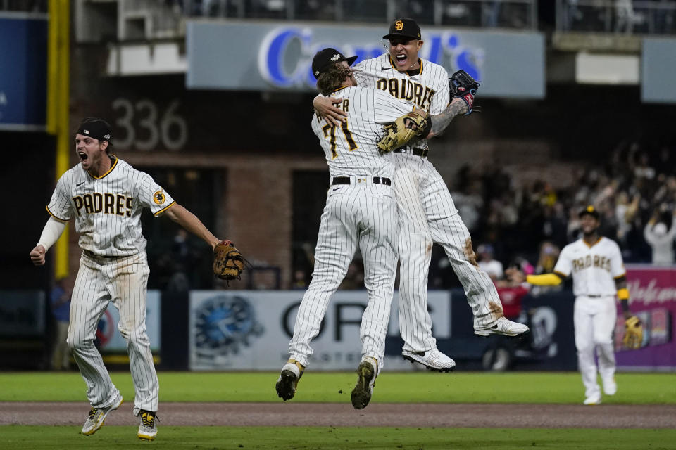 El tercera base de los Padres de San Diego Manny Machado (derecha) celebra con el relevista Josh Hader (71) luego que los Padres tras eliminar a los Dodgers de Los Ángeles en la serie divisional de la Liga Nacional, el sábado 15 de octubre de 2022, en San Diego.