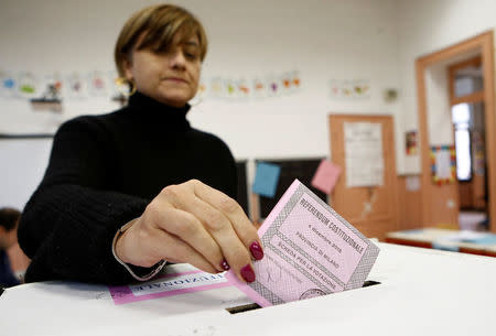 A woman casts her ballot during a referendum vote at a polling station in Milan, Italy, December 4, 2016. REUTERS/Alessandro Garofalo