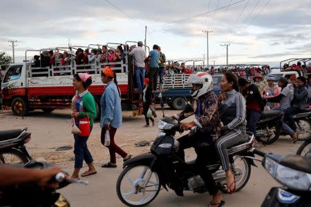 Workers wait for a pickup truck to take them home after working at Complete Honour Footwear Industrial, a footwear factory owned by a Taiwan company, in Kampong Speu, Cambodia, July 4, 2018. REUTERS/Ann Wang