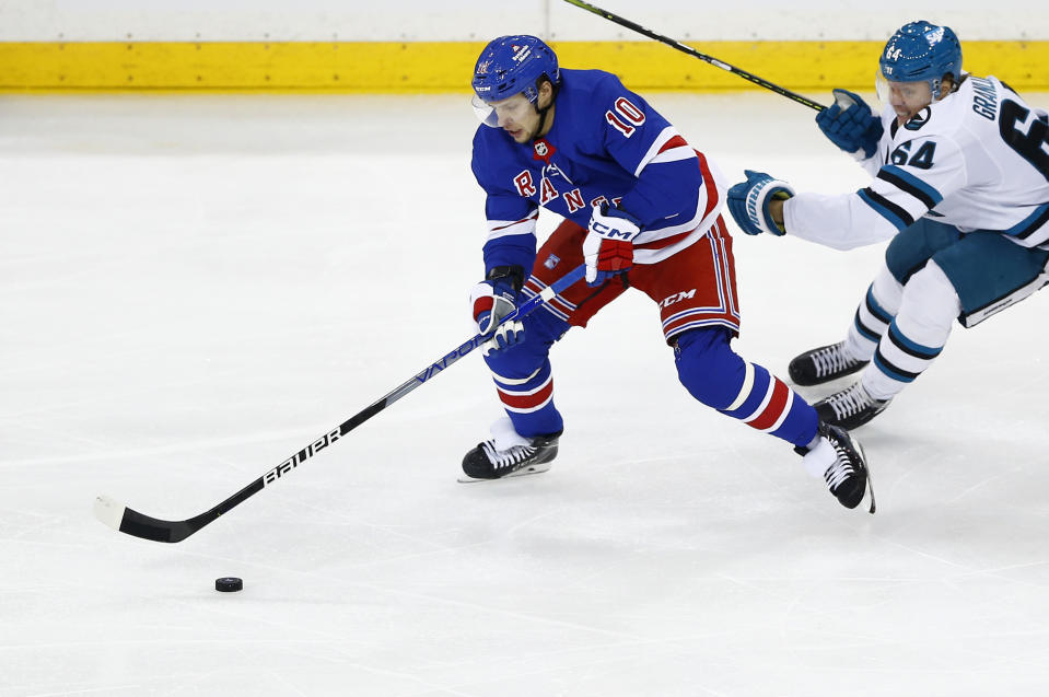 New York Rangers forward Artemi Panarin (10) controls the puck in front of San Jose Sharks center Mikael Granlund (64) during the third period of an NHL hockey game, Sunday, Dec. 3, 2023, in New York. (AP Photo/John Munson)