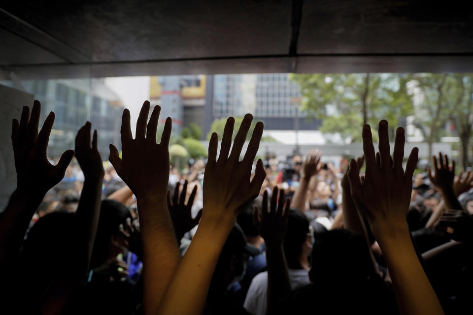 Protesters gesture inside the Hong Kong Revenue Tower as they block the building lobby to prevent people from entering in Hong Kong, Monday, June 24, 2019. Mass protests in recent weeks have occurred in Hong Kong over legislation that was seen as increasing Beijing's control and over police treatment of the protesters. (AP Photo/Kin Cheung)