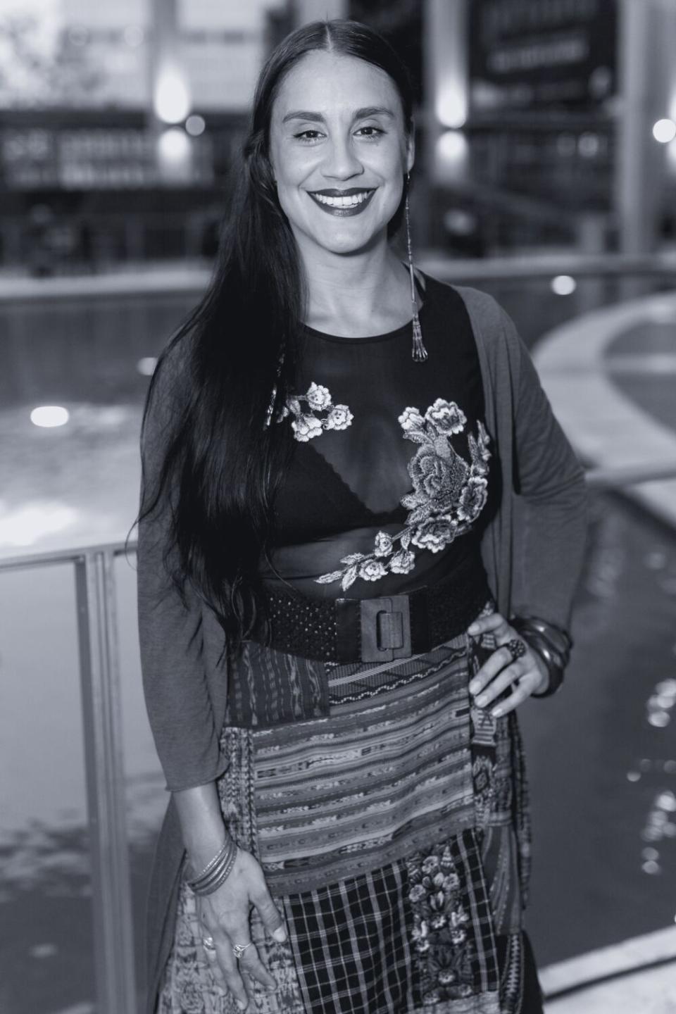 A smiling woman posing in a floral dress