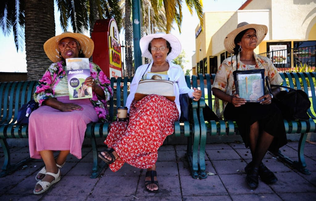 Jehovah’s Witnesses volunteer ministers from left 34 year residentof City of Compton Bell Stewart (L), Rose Godfrey (C), and Sarah Lee, wait to interact with people on July 19, 2012 in Compton, California. The City of Compton located south of Los Angeles with a population of nearly 100,000 must decide by September 1 whether to file for bankruptcy. According to city officials, Compton has an accumulated $43 million deficit and will run out of cash to make its payroll on September 1. (Photo by Kevork Djansezian/Getty Images)