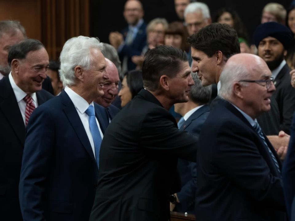 Prime Minister Justin Trudeau speaks with Paul Henderson and members of Team Canada from the 1972 Summit Series as they are honoured in the House of Commons Thursday. (Adrian Wyld/The Canadian Press - image credit)