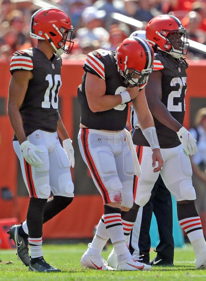Cleveland Browns quarterback Baker Mayfield (6) walks off the field after sustaining an injury to his left arm during the first half of an NFL football game against the Houston Texans, Sunday, Sept. 19, 2021, in Cleveland, Ohio. [Jeff Lange/Beacon Journal]
