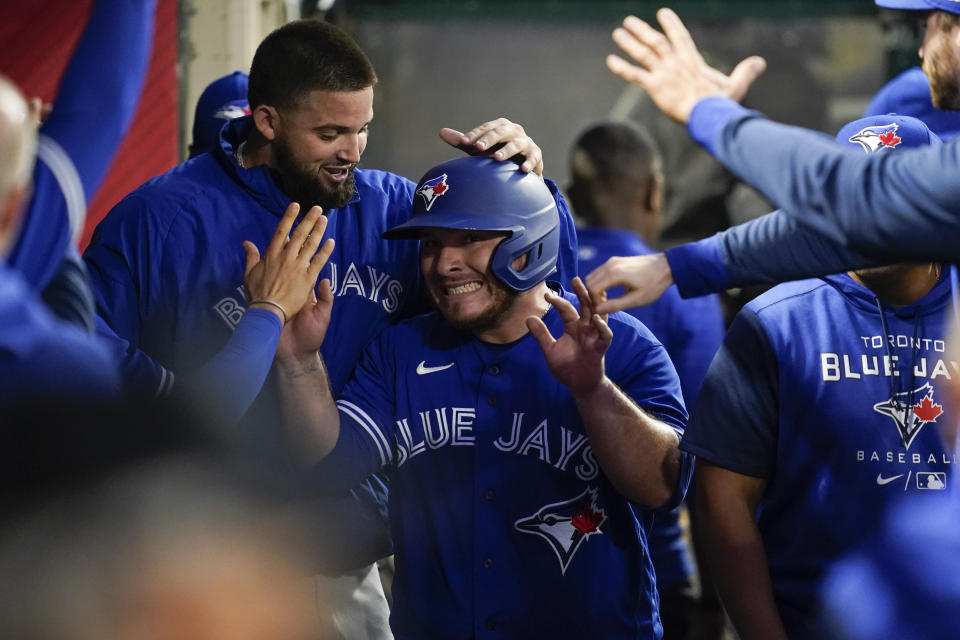 Toronto Blue Jays' Alejandro Kirk, center, celebrates in the dugout after scoring off a double hit by Lourdes Gurriel Jr. during the fifth inning of a baseball game against the Los Angeles Angels in Anaheim, Calif., Friday, May 27, 2022. (AP Photo/Ashley Landis)