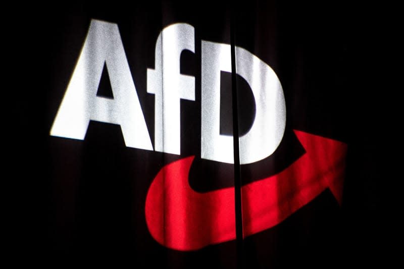 The Alternative for Germany (AfD) logo is projected onto a curtain at the national party conference. A 52 year old man threw an ashtray at an AfD politician in a pub. Sina Schuldt/dpa