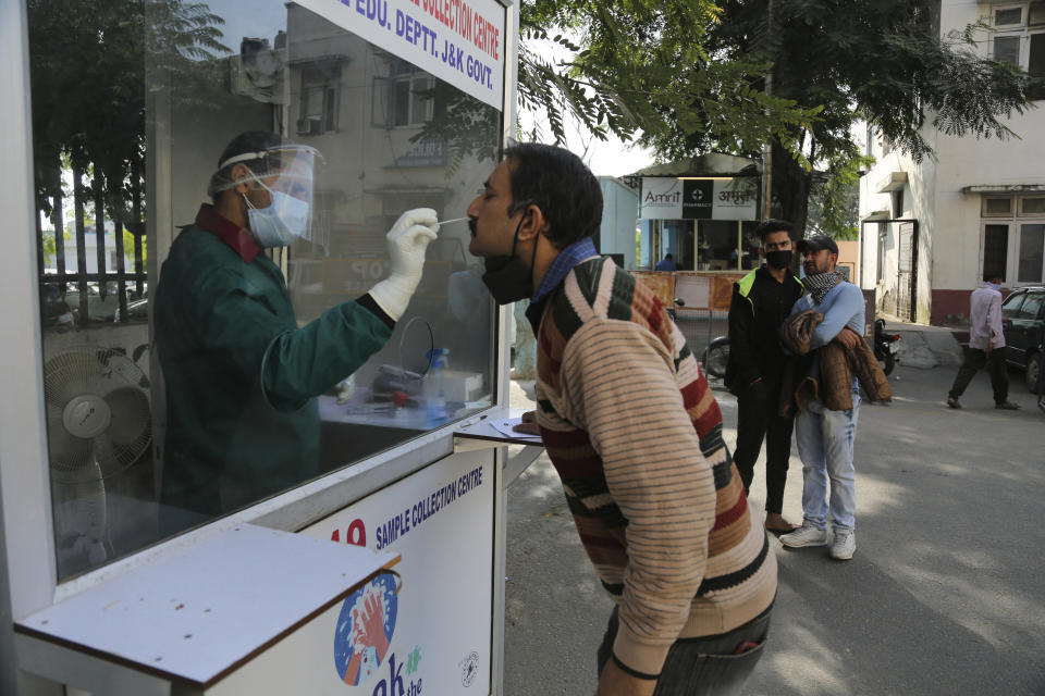 A health worker collects a nasal swab sample to test for COVID-19 at a government hospital in Jammu, India, Thursday, Oct.29, 2020. India's confirmed coronavirus caseload surpassed 8 million on Thursday with daily infections dipping to the lowest level this week, as concerns grew over a major Hindu festival season and winter setting in. (AP Photo/Channi Anand)
