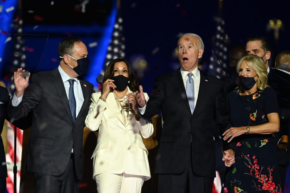 TOPSHOT - US President-elect Joe Biden (R) and Vice President-elect Kamala Harris (2nd L) react as confetti falls, with Jill Biden (R) and Douglas Emhoff, after delivering remarks in Wilmington, Delaware, on November 7, 2020, after being declared the winners of the presidential election. (Photo by Jim WATSON / AFP) (Photo by JIM WATSON/AFP via Getty Images)