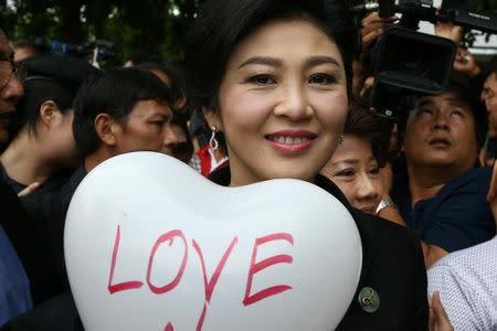 Ousted former Thai prime minister Yingluck Shinawatra holds a balloon as she arrives at the Supreme Court in Bangkok, Thailand, July 21, 2017. REUTERS/Athit Perawongmetha