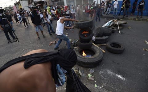 Venezuelans clash with national guards in the border town of Urena after Maduro´s government ordered to temporary close down the border with Colombia - Credit: AFP