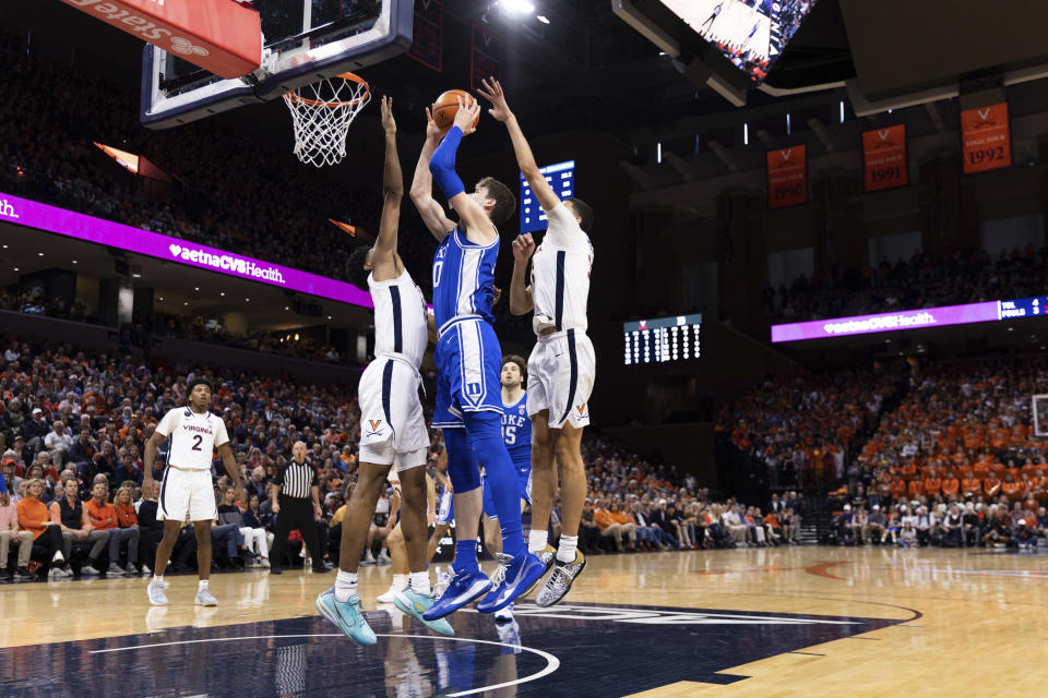 Duke's Kyle Filipowski (30) goes up for a basket defended by Virginia's Kihei Clark (0) during the first half of an NCAA college basketball game in Charlottesville, Va., Saturday, Feb. 11, 2023. (AP Photo/Mike Kropf)