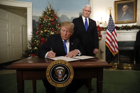 With Vice Pence Mike Pence looking on, U.S. President Donald Trump signs an executive order after he announced the U.S. would Jerusalem as the capital of Israel, in the Diplomatic Reception Room of the White House in Washington, U.S., December 6, 2017. REUTERS/Kevin Lamarque