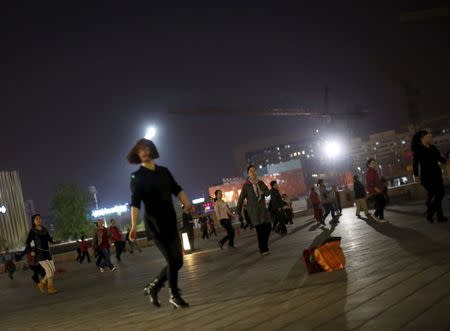 Women perform square dancing on a square in Beijing, China, April 14, 2015. REUTERS/Kim Kyung-Hoon