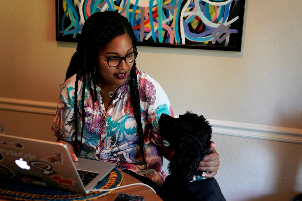 Jaleesa Garland, a marketing manager, pets her dog Bo while working in her apartment in Tulsa, Oklahoma, July 9, 2021. REUTERS/Nick Oxford