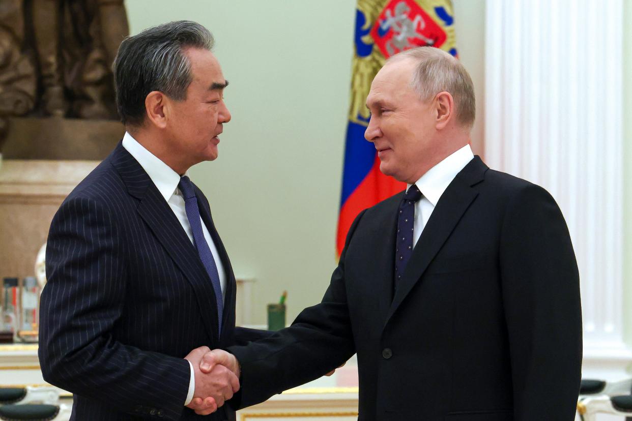Russian President Vladimir Putin greets Chinese Communist Party's foreign policy chief Wang Yi during their meeting at the Kremlin in Moscow, Russia, Wednesday, Feb. 22, 2023.