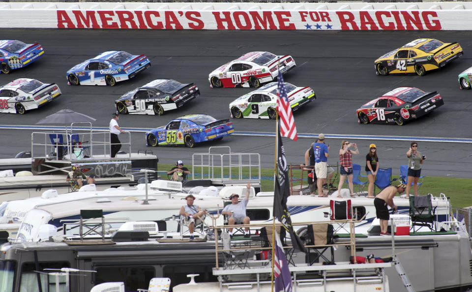 FILE - In this Sept. 29, 2018, file photo, fans watch as drivers race during the NASCAR Xfinity series auto race at Charlotte Motor Speedway in Concord, N.C. Some fans have been coming to the Coca-Cola 600 for decades, but they won’t be allowed into Charlotte Motor Speedwaý on Sunday due to Covid-19, leaving the grandstands empty and many disappointed. (AP Photo/Bob Jordan, File)