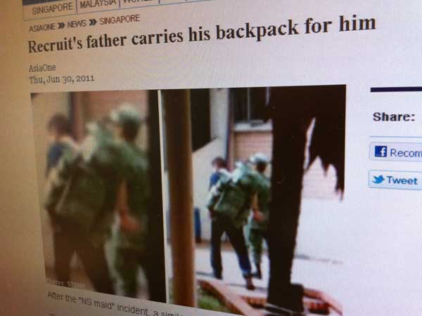 These images have sparked speculation of a father carrying his national serviceman son's backpack. (Screenshot)