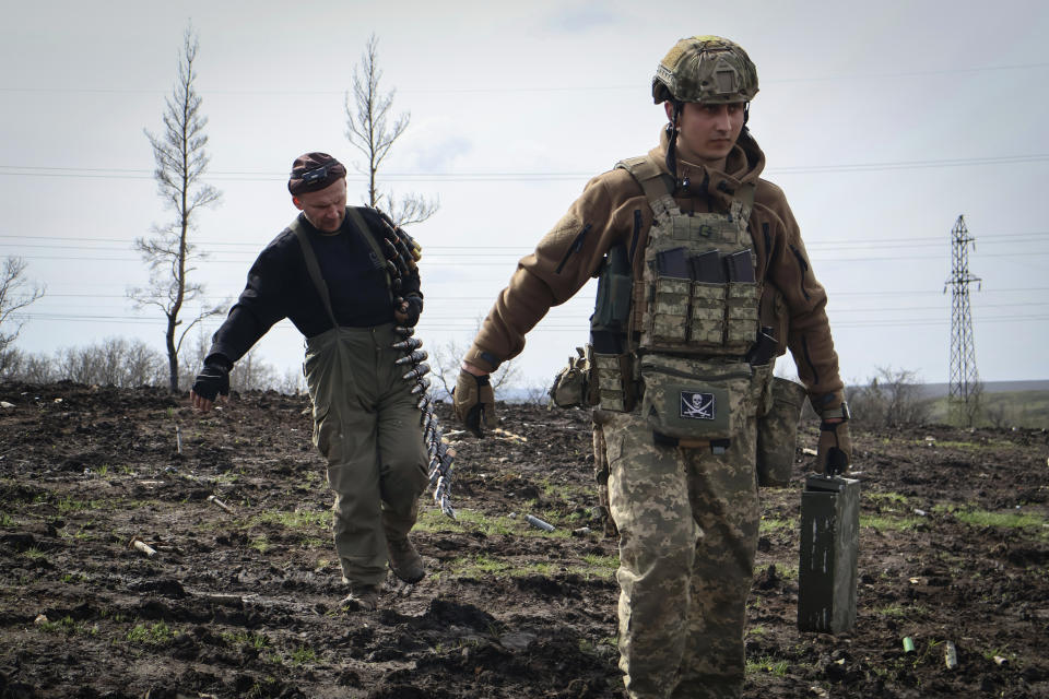 Ukrainian soldiers carry cartridges in their position on the frontline, near Bakhmut, Donetsk region, Ukraine, Friday, April 7, 2023. (Roman Chop via AP)