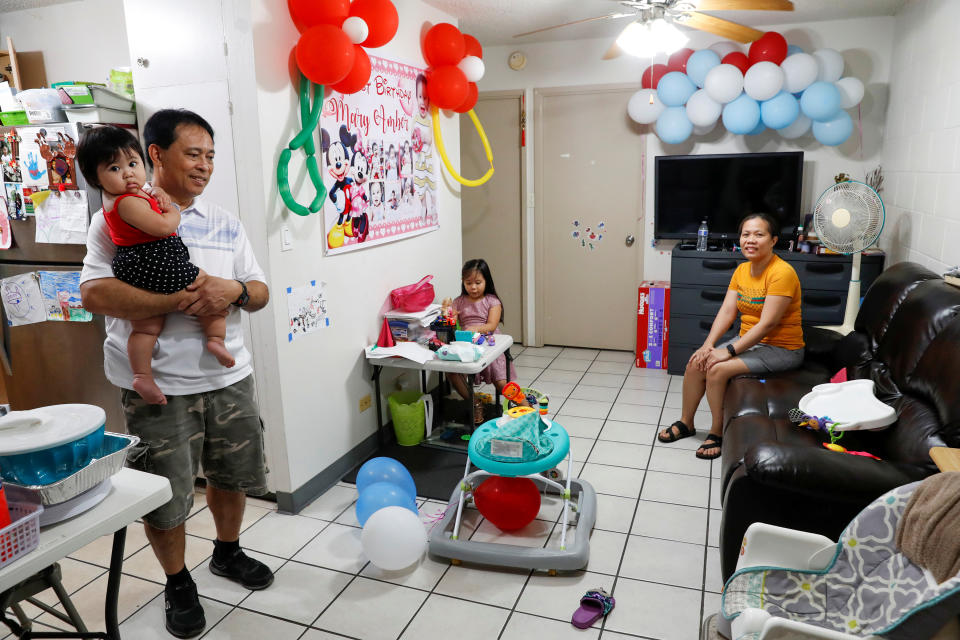 Una pareja, que ha sido despedida de sus trabajos en un hotel, posan en su casa junto a sus hijos en Honolulu, Hawái. (REUTERS/Marco Garcia)