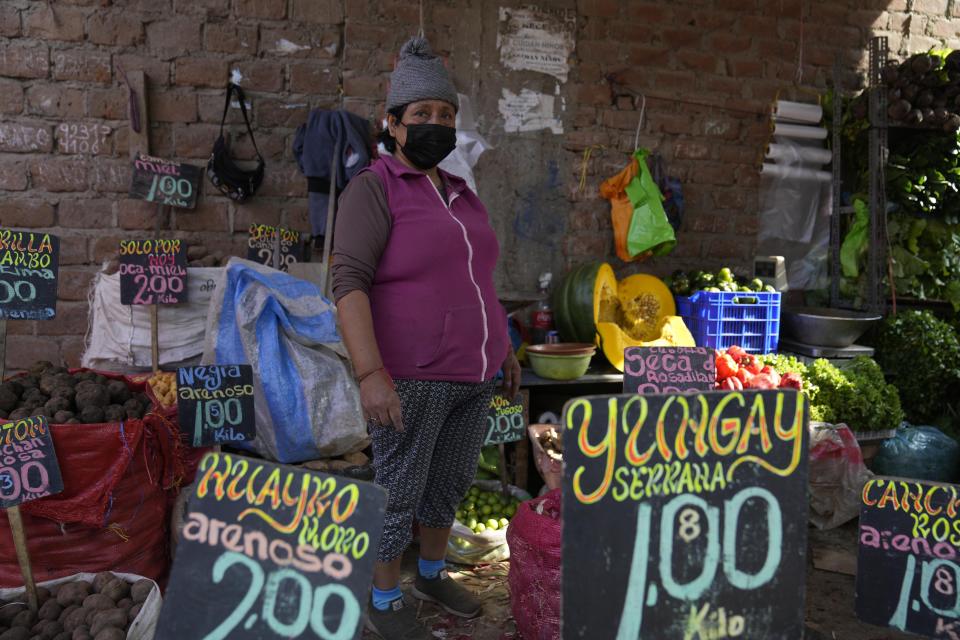 A potato vendor waits for clients at the Juan Velasco Market in the Villa El Salvador neighborhood of Lima, Peru, Tuesday, April 12, 2022. Community soup kitchens are once again on the rise as a lifeline for increasing swathes of the Andean country's population as global spikes in food and fuel prices are proving a double whammy for Peru. (AP Photo/Martin Mejia)