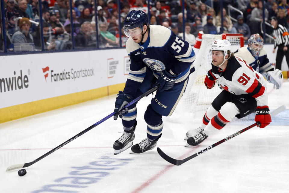 Columbus Blue Jackets defenseman David Jiricek, left, controls the puck in front of New Jersey Devils forward Dawson Mercer, right, during the first period an NHL hockey game in Columbus, Ohio, Saturday, Dec. 16, 2023. (AP Photo/Paul Vernon)