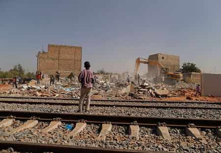 A child watches municipal workers destroy a house to build a new road beside the new tracks for a high speed railway in Mbao, on the outskirts of Dakar, Senegal February 12, 2019. Picture taken February 12, 2019. REUTERS/Zohra Bensemra