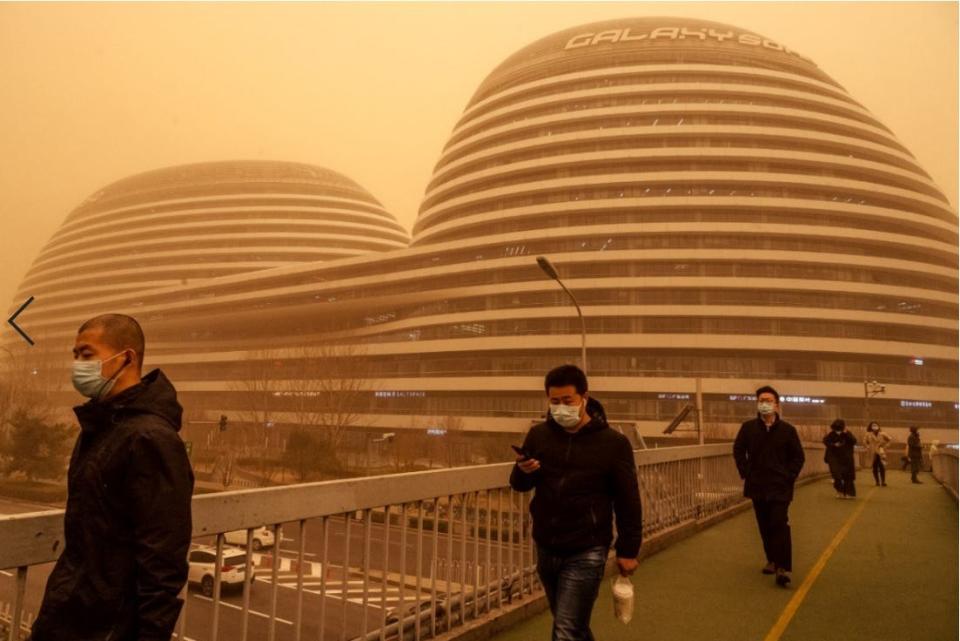 People wear protective masks as they commute during a sandstorm on March 15, 2021 in Beijing, China.