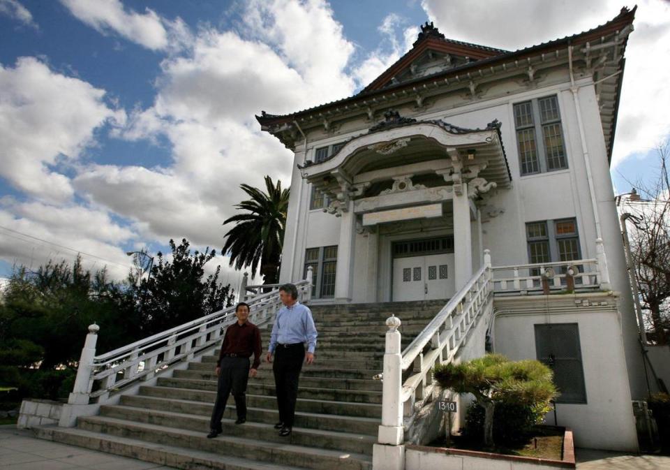 Cliff Osaki, board member of the Fresno Betsuin Buddhist Temple, left, and realtor Mike Ryan, of Colliers International, right, descend the stairs of the historic temple, in this file photo from 2011. The historic temple on Kern Street is an architectural gem in Fresno’s Chinatown.