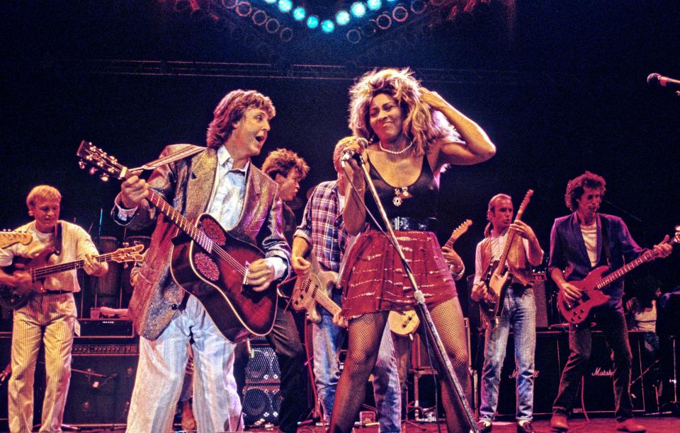 LONDON - JUNE 20: Paul McCartney and Tina Turner performing on stage at The Prince's Trust 10th Birthday Party at Wembley Arena, London, United Kingdom on 20th June 1986. Behind them from left to right are: Mark King, Paul Young, Bryan Adams, Francis Rossi and John Illsley.