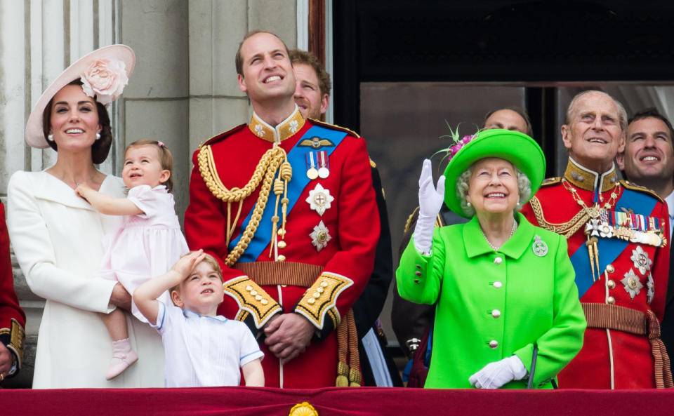 Duchess of Cambridge, Prince George, Princess Charlotte, Prince William, Prince Harry, Queen Elizabeth II, and Prince Philip, Duke of Edinburgh watch as the Royal Air Force flies by. 