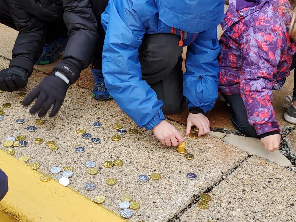 Kids scramble to retrieve gold and silver chocolate coins after they were dropped from a fire truck ladder Sunday beginning a Hanukkah celebration at the Mall at Fox Run in Newington Sunday Nov. 28, 2021.
