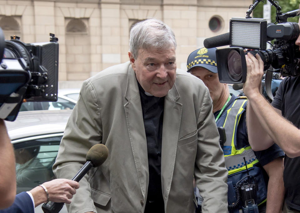 FILE - In this Feb. 26, 2019, file photo, Cardinal George Pell arrives at the County Court in Melbourne, Australia. High-profile Australian journalists face possible prison sentences, and large media organizations could face fines after being ordered to appear in court next month for allegedly breaching a gag order on reporting about Pell's convictions on charges of sexually molesting two choirboys. (AP Photo/Andy Brownbill, File)