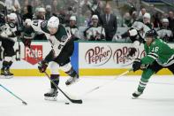 Arizona Coyotes left wing Lawson Crouse (67) shoots as Dallas Stars center Joe Pavelski (16) defends in the second period of an NHL hockey game in Dallas, Monday, Dec. 6, 2021. (AP Photo/Tony Gutierrez)