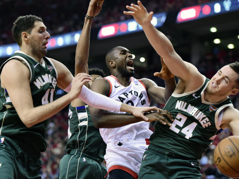 Toronto Raptors center Serge Ibaka (9) battles for the rebound against Milwaukee Bucks forward Nikola Mirotic (41) and Milwaukee Bucks guard Pat Connaughton (24) during the second half of Game 4 of the NBA basketball playoffs Eastern Conference finals, Tuesday, May 21, 2019 in Toronto. (Frank Gunn/The Canadian Press via AP)