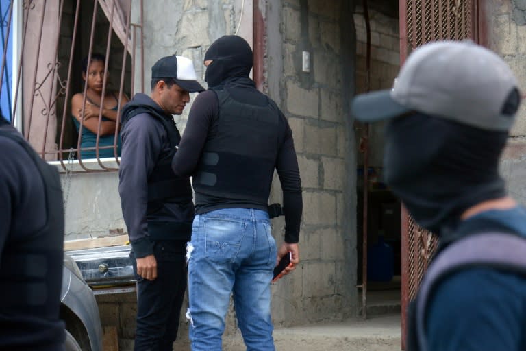 Una mujer mira por la ventana durante un operativo de militares y policías para recuperar viviendas tomadas por bandas del narcotráfico en Durán, a 10 km de Guayaquil, Ecuador, el 23 de julio de 2024 (Gerardo MENOSCAL)