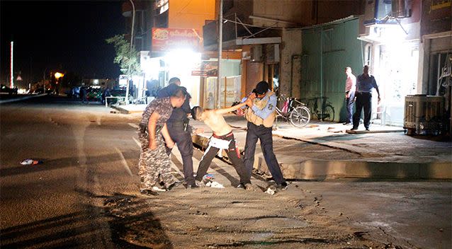 Uniformed men work to restrain and disarm the boy. Photo: Reuters/Ako Rasheed