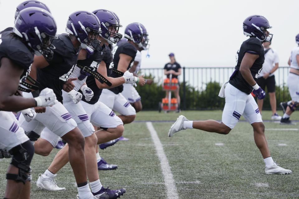 Northwestern football players warm up during team's practice in Evanston, Ill., Wednesday, Aug. 9, 2023. (AP Photo/Nam Y. Huh)