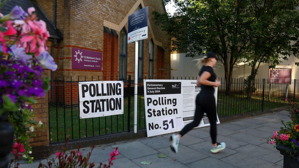 A person runs past a polling station shortly before the polls open and voting begins in the UK general election in London, Britain, on July 4, 2024. - Kevin Coombs/Reuters