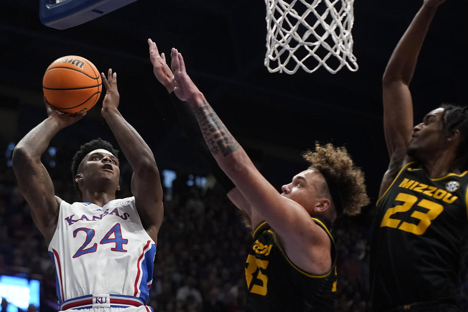 Kansas forward K.J. Adams Jr. (24) shoots under pressure from Missouri forwards Noah Carter (35) and Aidan Shaw (23) during the first half of an NCAA college basketball game Saturday, Dec. 9, 2023, in Lawrence, Kan. (AP Photo/Charlie Riedel)