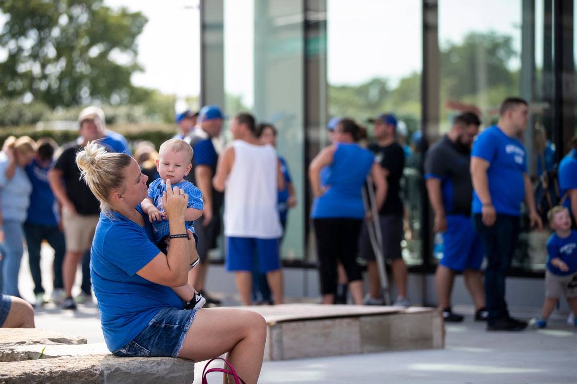 Jasmine McClanahan holds her son Jett while waiting in line for Tuesday’s open practice. McClanahan, a UK graduate, said she drove from Ohio for the fundraiser.