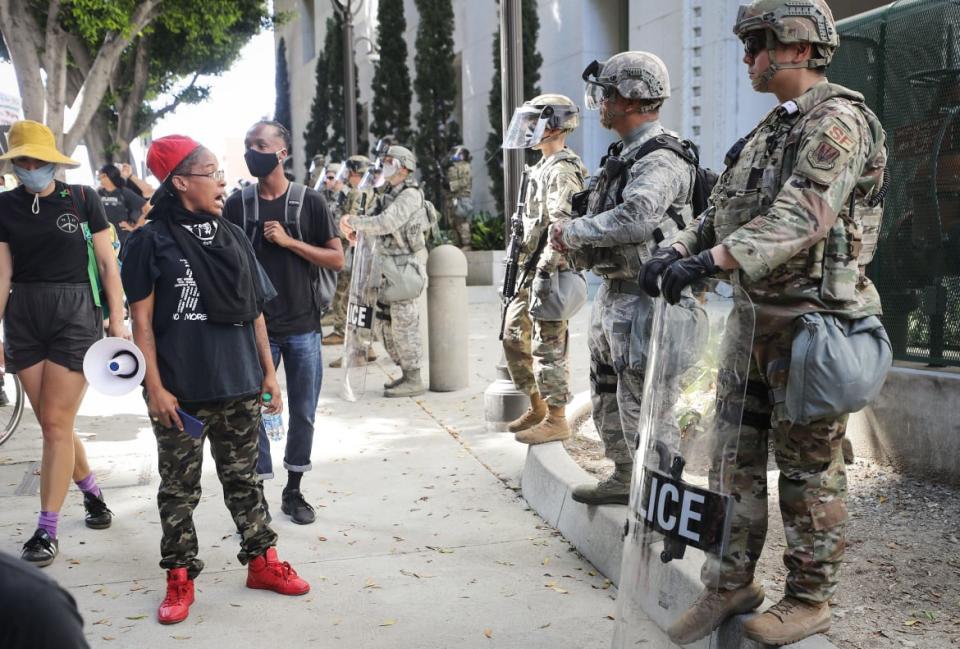 <div class="inline-image__caption"><p>A protester speaks to National Guard troops posted outside the Los Angles District Attorney’s office.</p></div> <div class="inline-image__credit">Mario Tama/Getty</div>