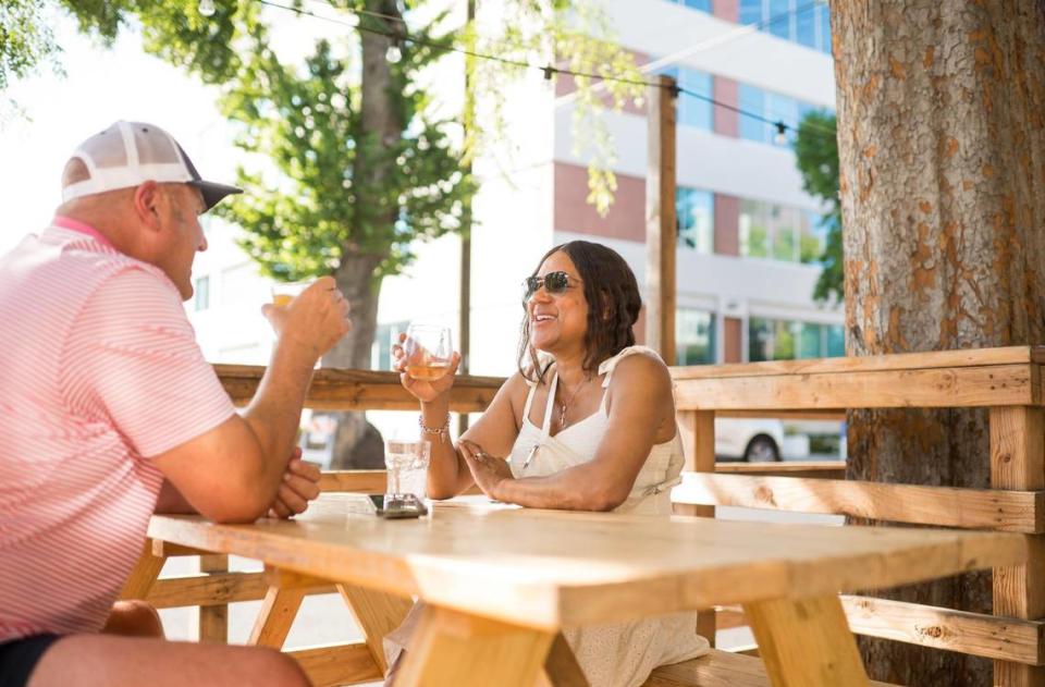 Regulars Samara Palko, right, and husband Pater Palko, midtown Sacramento residents for 19 years, enjoy drinks in Kupros Craft House’s outdoor parklet Friday, May 12, 2023, in 21st Street. “Keegan is a great owner, and does such a good job making sure his business is safe for the community,” Samara said.