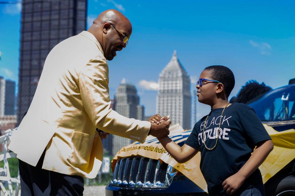 Darren McCormick, an Alpha Phi Alpha Pittsburgh Chapter member, teaches a handshake to Brian Cook Jr., during the Juneteenth Voting Rights Parade lineup on Saturday, June 18, 2022, in Pittsburgh, Pennsylvania. On Saturday, community groups and leaders marched in the Juneteenth Voting Rights Parade from Freedom Corner to Point State Park.