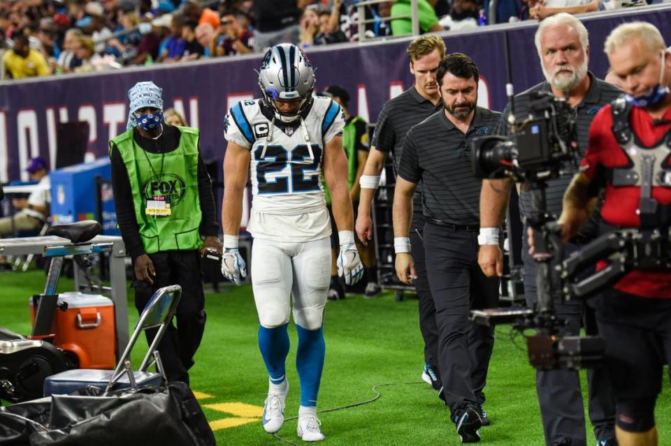 Panthers running back Christian McCaffrey, center, hangs his head as he leaves the medical tent after a hamstring injury during the game against the Texans at NRG Stadium on Thursday, September 21, 2021 in Houston, TX.