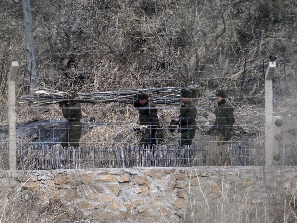 North Korean soldiers carrying wood.