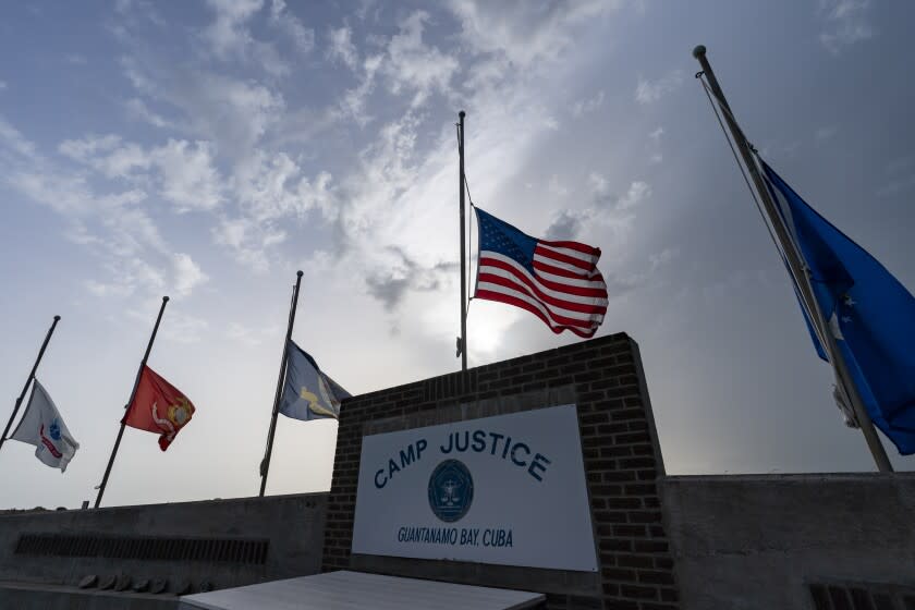 FILE - In this photo reviewed by U.S. military officials, flags fly at half-staff at Camp Justice, Aug. 29, 2021, in Guantanamo Bay Naval Base, Cuba. Majid Khan, a former Maryland man held at the Guantanamo Bay detention center, has languished in custody months after his scheduled release date despite his cooperation with authorities as part of a plea deal, according to a federal suit filed that seeks his immediate release. (AP Photo/Alex Brandon, File)