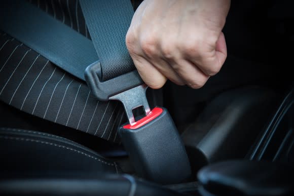 Hand fastening seat belt in the car.